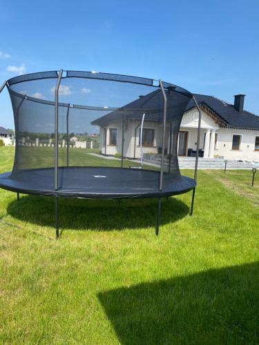 a trampoline in the grass in a yard at Dworek pod Krzyżtoporem Ujazd Agroturystyka- pokoje do wynajęcia in Iwaniska