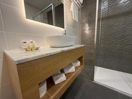 a bathroom with a sink and a shower at Villa Lijó Suites in Rio Caldo