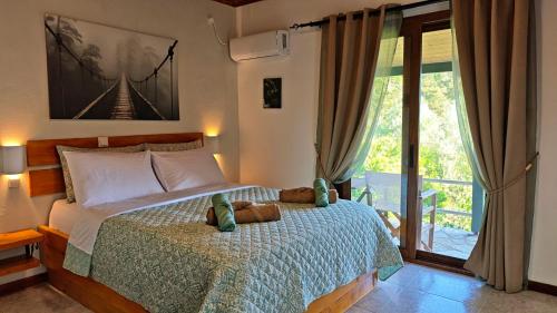 a bedroom with a bed and a large window at Liokorni Village in Gaios