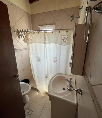 a bathroom with a shower curtain and a sink at Amanecer y Canela in Mina Clavero
