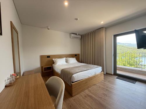 a bedroom with a bed and a table and a window at Villa Lijó Suites in Rio Caldo