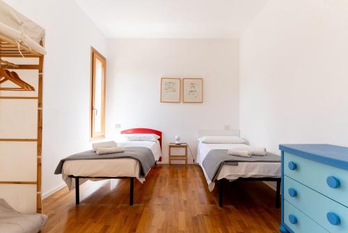 a bedroom with two beds and a blue dresser at Casa Vacanza 2 Mari in Alghero