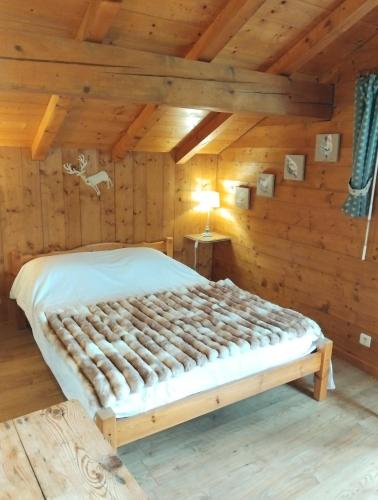 a bedroom with a bed in a log cabin at Chalet Indépendant " L'anfian-ne" in Les Contamines-Montjoie