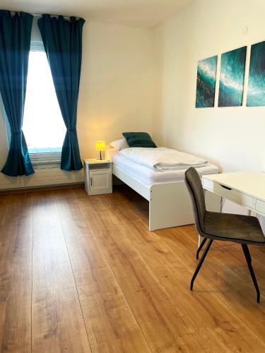 een slaapkamer met een bed, een bureau en een stoel bij Xerio Motel in Horn