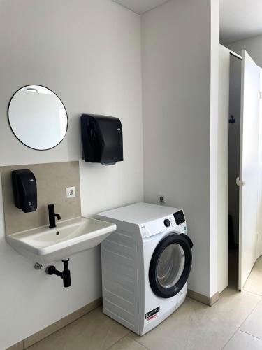 een wasmachine in een badkamer met een wastafel bij Xerio Motel in Horn