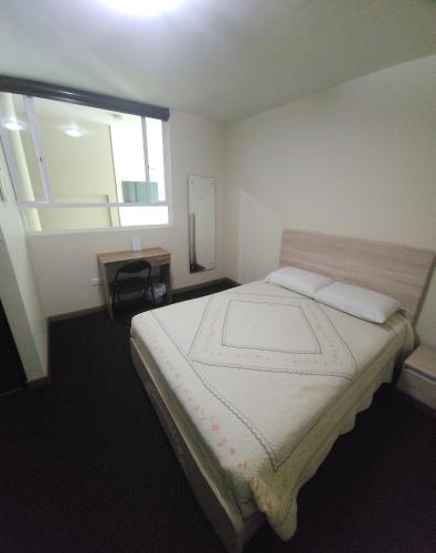 a bedroom with a large bed with a window at Vincent Suites Hotel in Pasto