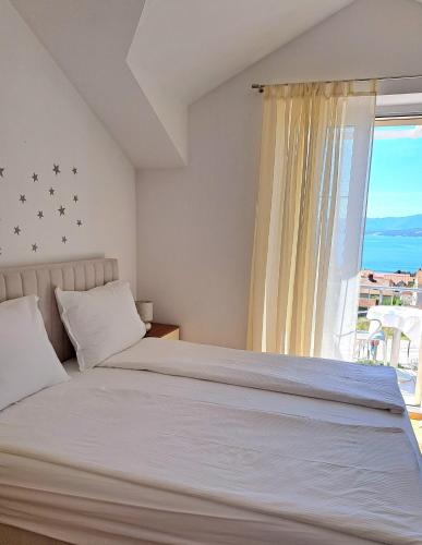 a bedroom with a bed and a large window at Studio Apartments Regina in Bol