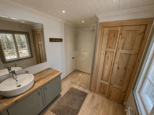 a bathroom with a sink and a mirror and a shower at HomeSweetSweden in Malung