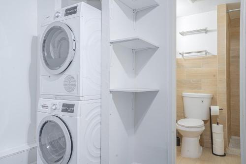a bathroom with a washing machine and a toilet at Charm 2Bd in Upper East Side with Backyard in New York
