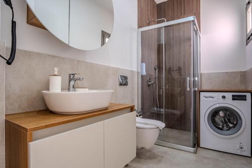 a bathroom with a sink and a washing machine at Kaura Villas in Milas