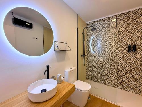 a bathroom with a sink and a toilet and a mirror at YourHouse O Foxo in Allariz