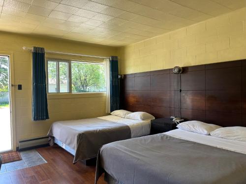 a room with two beds and a window at Motel R-100 in Longueuil