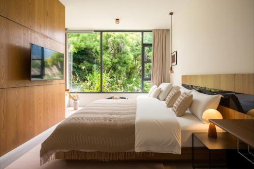 a bedroom with a large bed and a large window at 微云隐舍 in Jiazaiwei