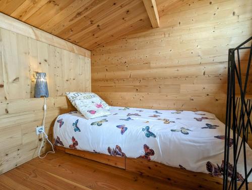 a bedroom with a bed in a wooden cabin at Ecogîte Les Papillons des Sucs in Saint-Maurice-de-Lignon