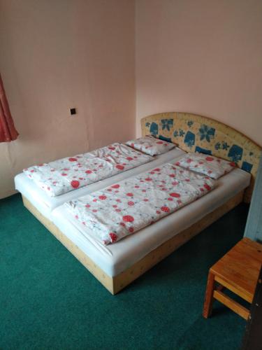 two beds in a room with red flowers on them at Chata Jablunka, Dog friendly, 50m ski slope, 50m restaurant in Pec pod Sněžkou