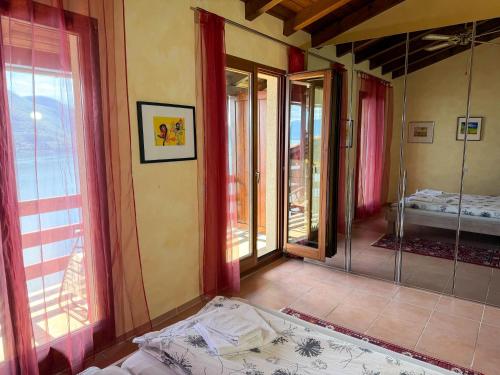 a room with a bed and a room with windows at Parco Esotico by HolAp SA in Brissago