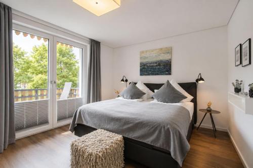 a bedroom with a bed and a large window at Wohnart - Fewo 1 Wohnstil in Norderney
