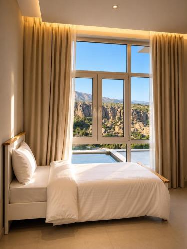 a bedroom with a large bed and a large window at Seeq view in Sayq