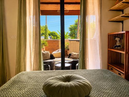 a bedroom with a bed with a large window at Lodge Sakayu - Charme, calme & piscine privée in Saint-Louis