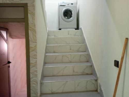 a staircase with a washing machine in a room at Kaltouma in Sidi Bibi