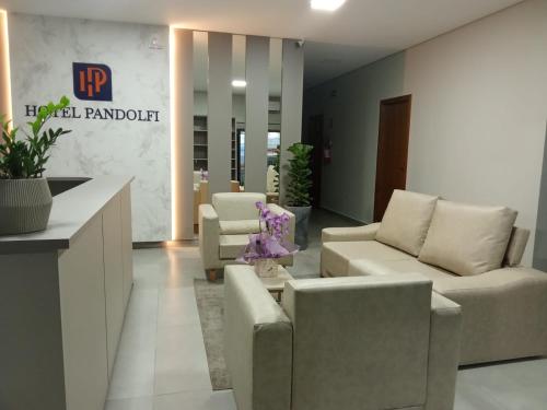 eine Lobby mit Sofas und Stühlen in einem Gebäude in der Unterkunft Hotel Pandolfi in Dois Vizinhos