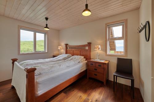 a bedroom with a bed and a desk and a chair at Brekka in Akranes