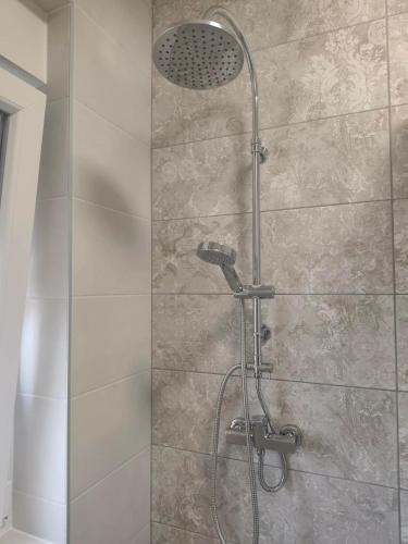 a shower with a shower head in a bathroom at APARTMAN I SOBE MARIJANA in Rab