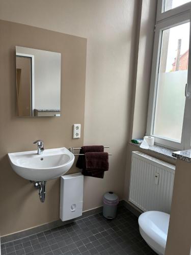 a bathroom with a sink and a toilet and a mirror at Gästehaus Lelo 1 in Solingen
