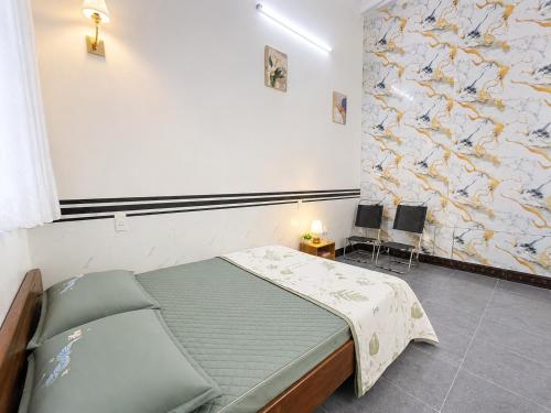 a bedroom with a bed and a painting on the wall at Phòng nghỉ 24h in Trung Nghĩa