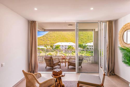 a living room with a view of a balcony at Suite prestige Serenity Bay devant la plage in Anse Marcel 