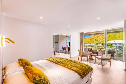 a bedroom with a large bed and a balcony at Suite prestige Serenity Bay devant la plage in Anse Marcel 