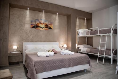 a bedroom with a bed with two bunk beds at Il Vicolo al Centro in Raffadali