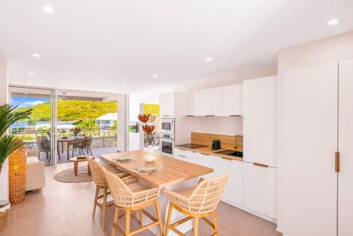 a kitchen and dining room with a wooden table and chairs at Suite prestige Karibean Paradise devant la plage in Anse Marcel 
