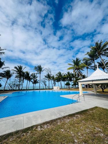 a large swimming pool with palm trees in the background at 11 Residence Thalassa in Belle Mare