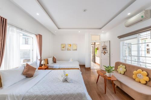 a living room with two beds and a couch at Chic Studio Homestay in Hue