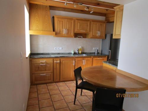 a kitchen with wooden cabinets and a wooden table at Etxexuriko Borda in Aïnhoa