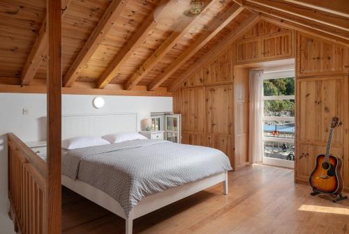 a bedroom with a bed and a guitar at Villa Insula by Belmont Realty in Vela Luka