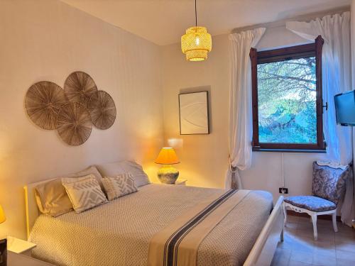 a bedroom with a bed and a window at Grace House in Marina di Sorso
