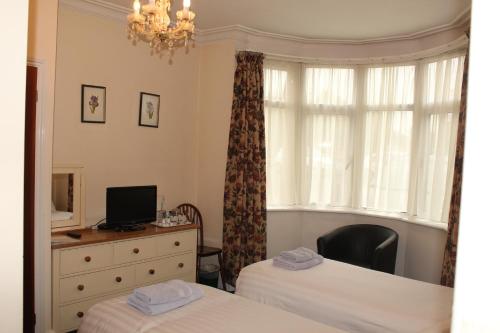 a bedroom with two beds and a dresser and a window at Lantern House in Cambridge