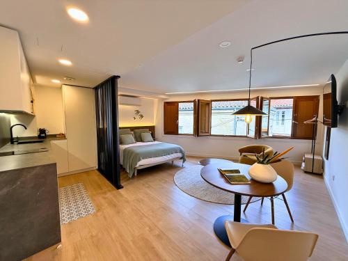 a bedroom with a bed and a table in a room at YourHouse As Escadas in Allariz