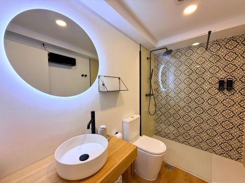 a bathroom with a sink and a toilet and a mirror at YourHouse As Escadas in Allariz