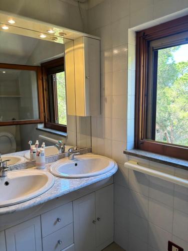 a bathroom with two sinks and a large mirror at Grace House in Marina di Sorso