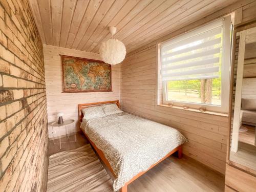 a small bedroom with a bed and a window at Serce Puszczy in Drawsko