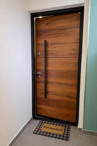 a wooden door with a welcome mat in front of it at 105 - Voiron centre - DeTassigny in Voiron