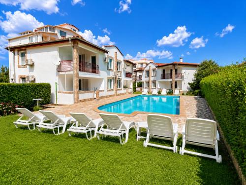 a villa with a swimming pool and lawn chairs at Complex Sea & Sky next to the Beach ! in Kranevo