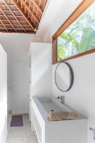 a bathroom with a sink and a mirror at NEW Sawah Escape - Tropical 2BR with Pool and Views in Tabanan