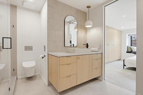 a bathroom with a sink and a toilet and a mirror at Modern Encinitas Retreat in Encinitas
