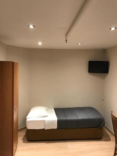 a bedroom with a bed and a television on the wall at Royal Hotel in Brussels