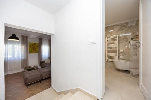 a living room with a couch and a bath tub at Lux suite in Split- Jacuzzi&Gym&more in Solin
