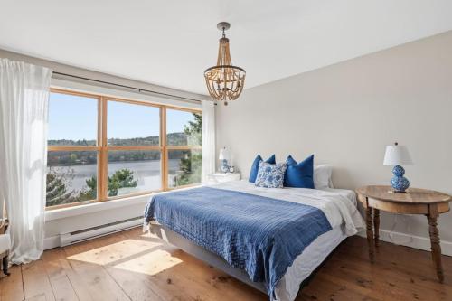 a bedroom with a bed and a large window at Oceanfront House Steps to Water in French Village